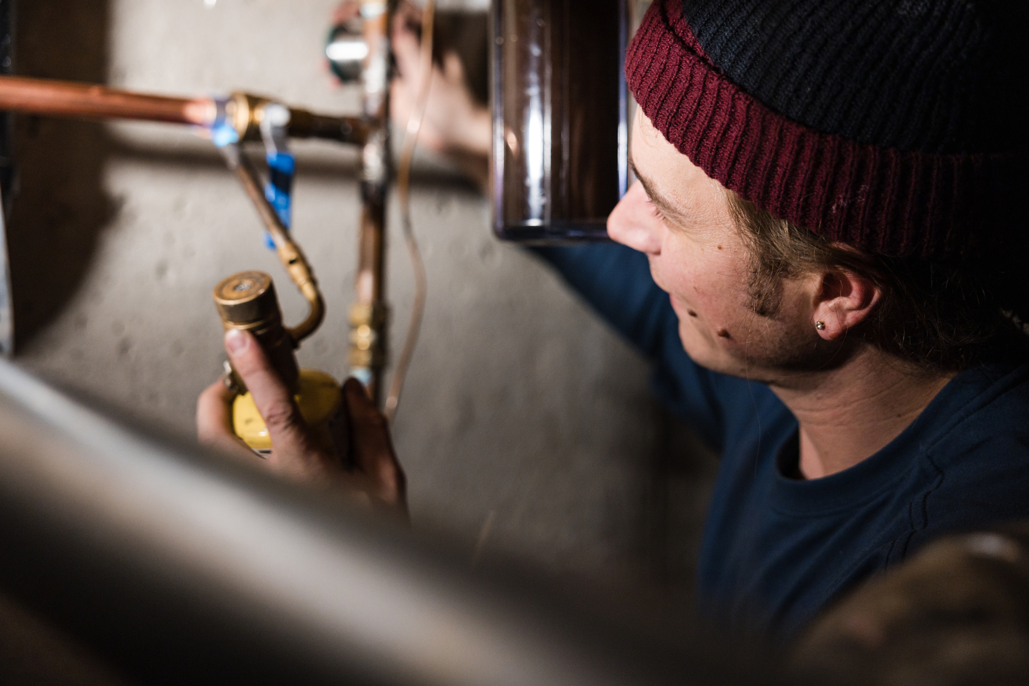 Plumber soldering copper pipe with a torch