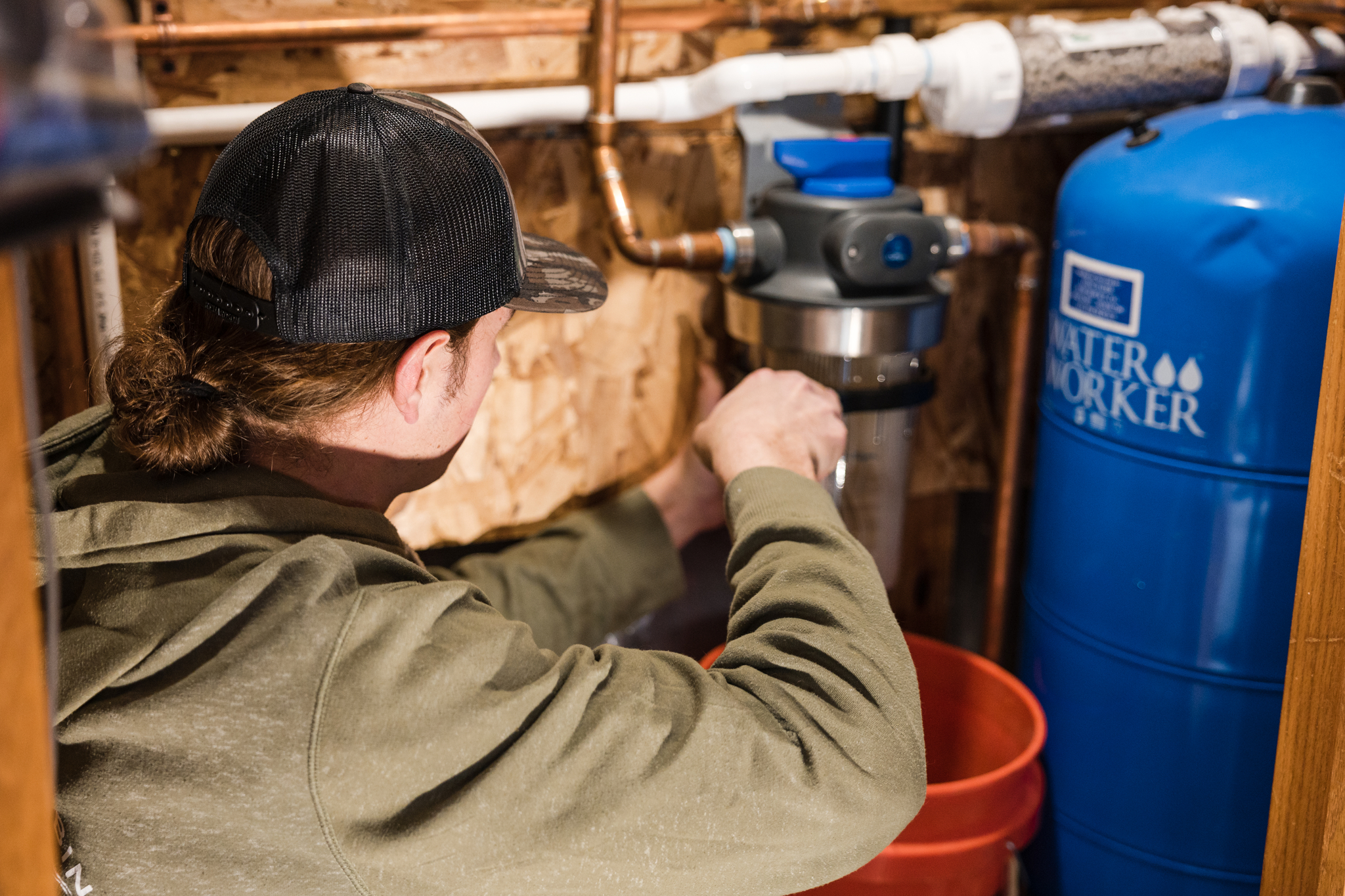 Plumber servicing a water softener and filtration system